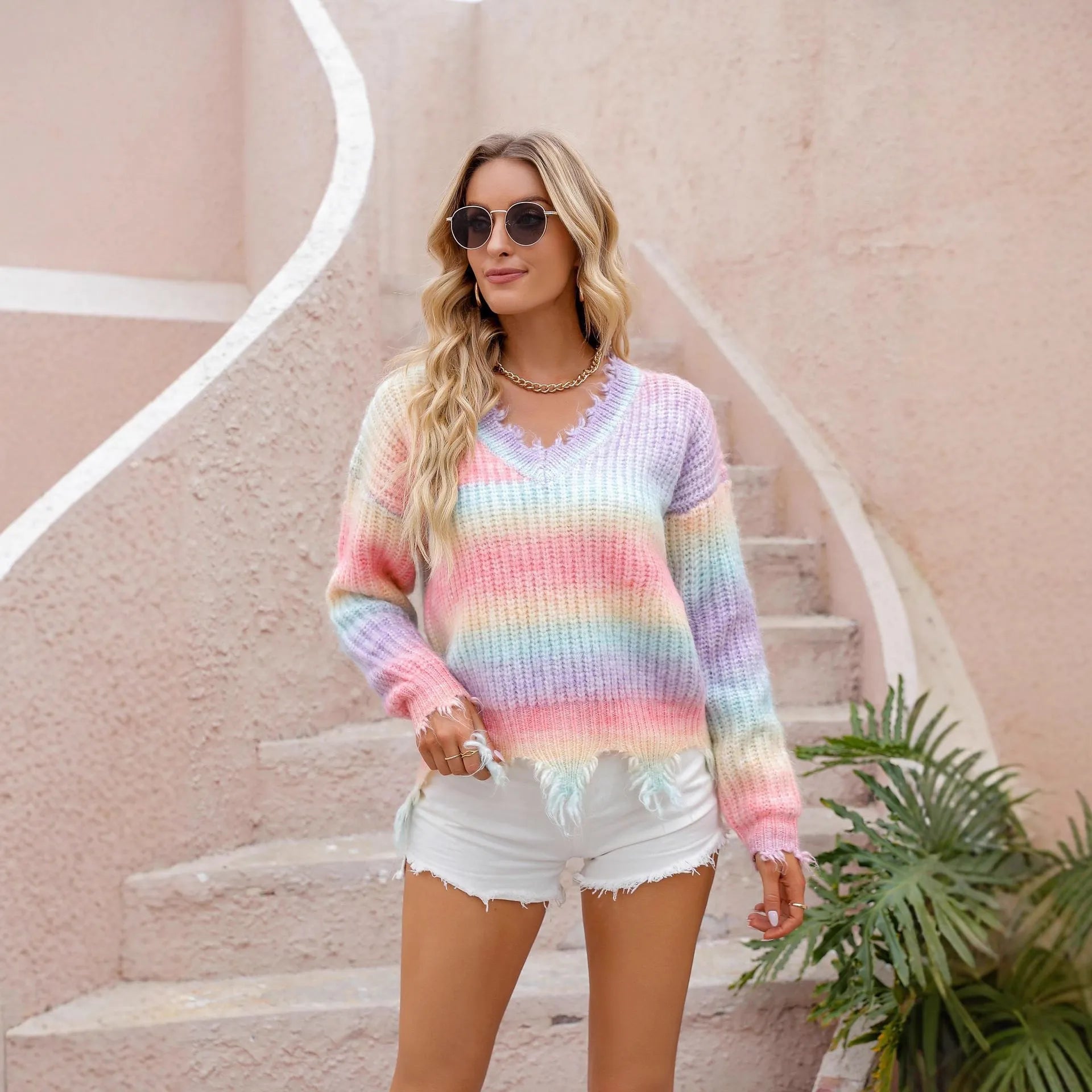 Pink rainbow gradient loose knitted sweater with tassel detail on mannequin