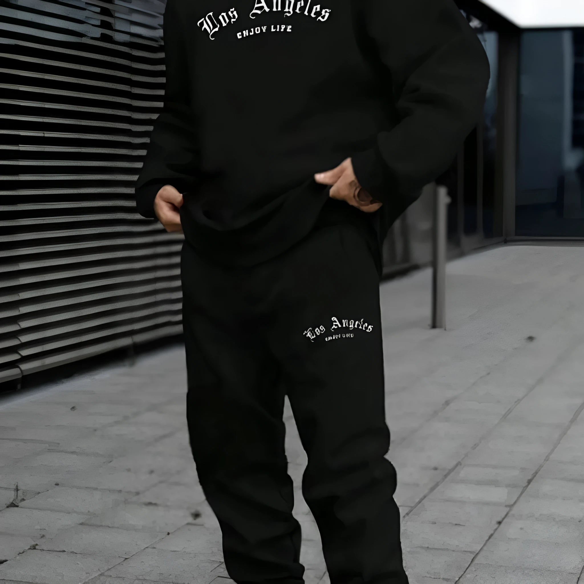 Man wearing a grey hooded polyester tracksuit with matching trousers, set on a plain background.