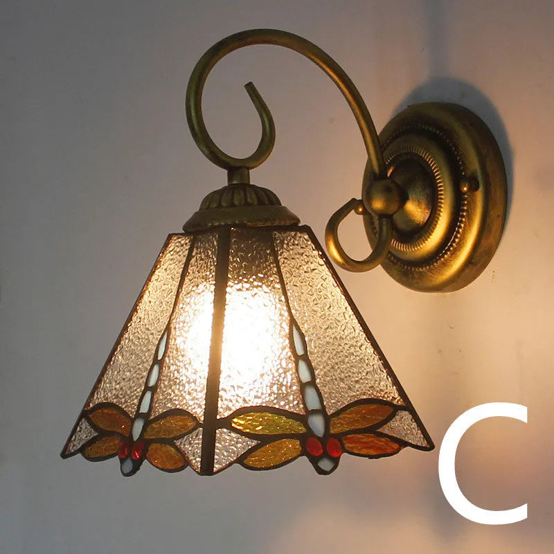 A coloured stained glass wall lamp in a simple contemporary style, mounted on a wall.