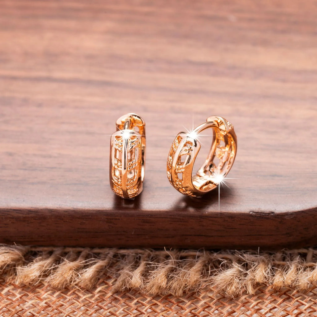 Rose gold plated copper earrings with hollowed-out heart and leaf shapes on a white background.