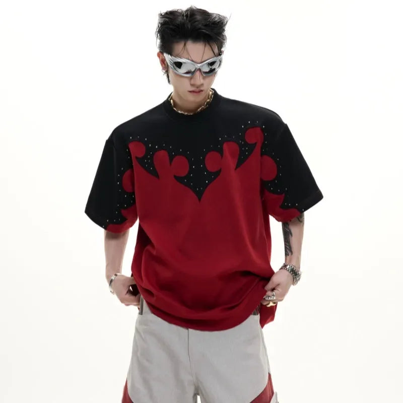 Close-up of a men's grey t-shirt with raised burnt flower embroidery and sparkling rhinestone details on the chest.