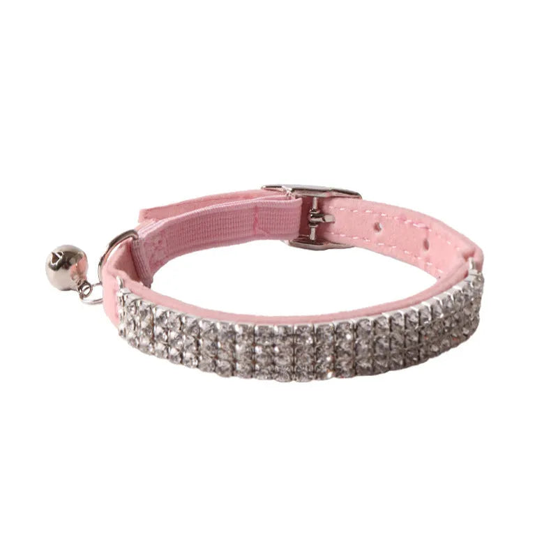 Soft pink flocked cat collar with an elastic section and plastic buckle on a grey background.