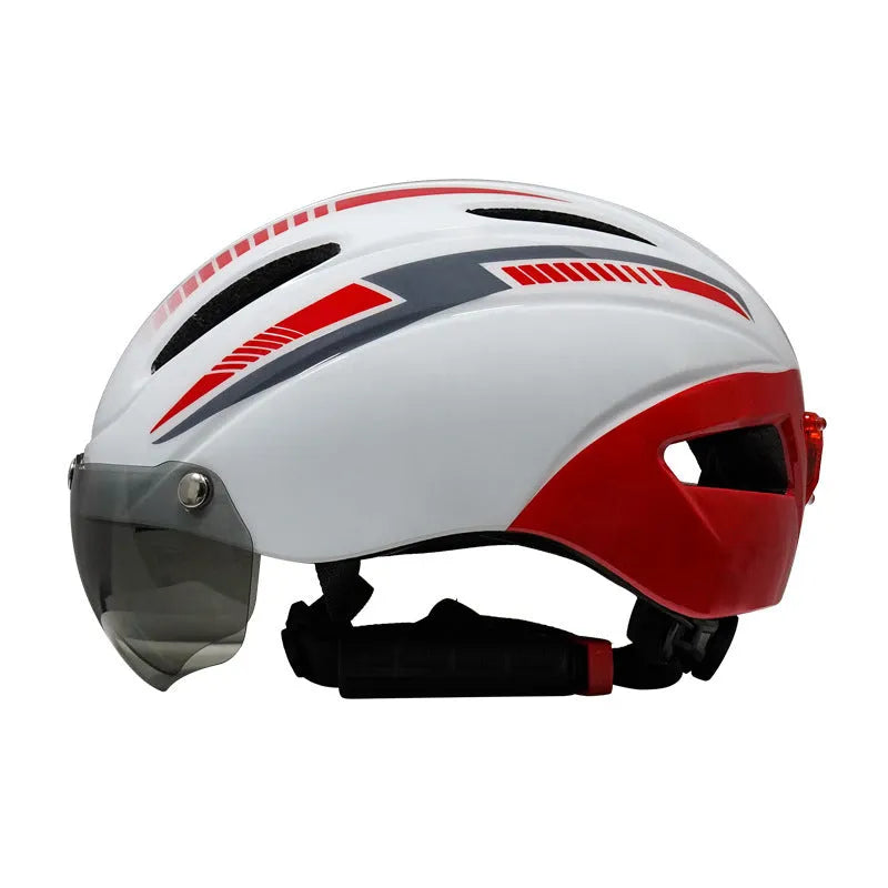 Adult bicycle helmet with integrated red taillight on back and a pair of black sports goggles, shown in a black and blue colour scheme.