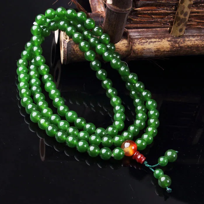 Green jade Buddhist prayer bead bracelet with 108 beads, Buddha head charm, and modern minimalist style