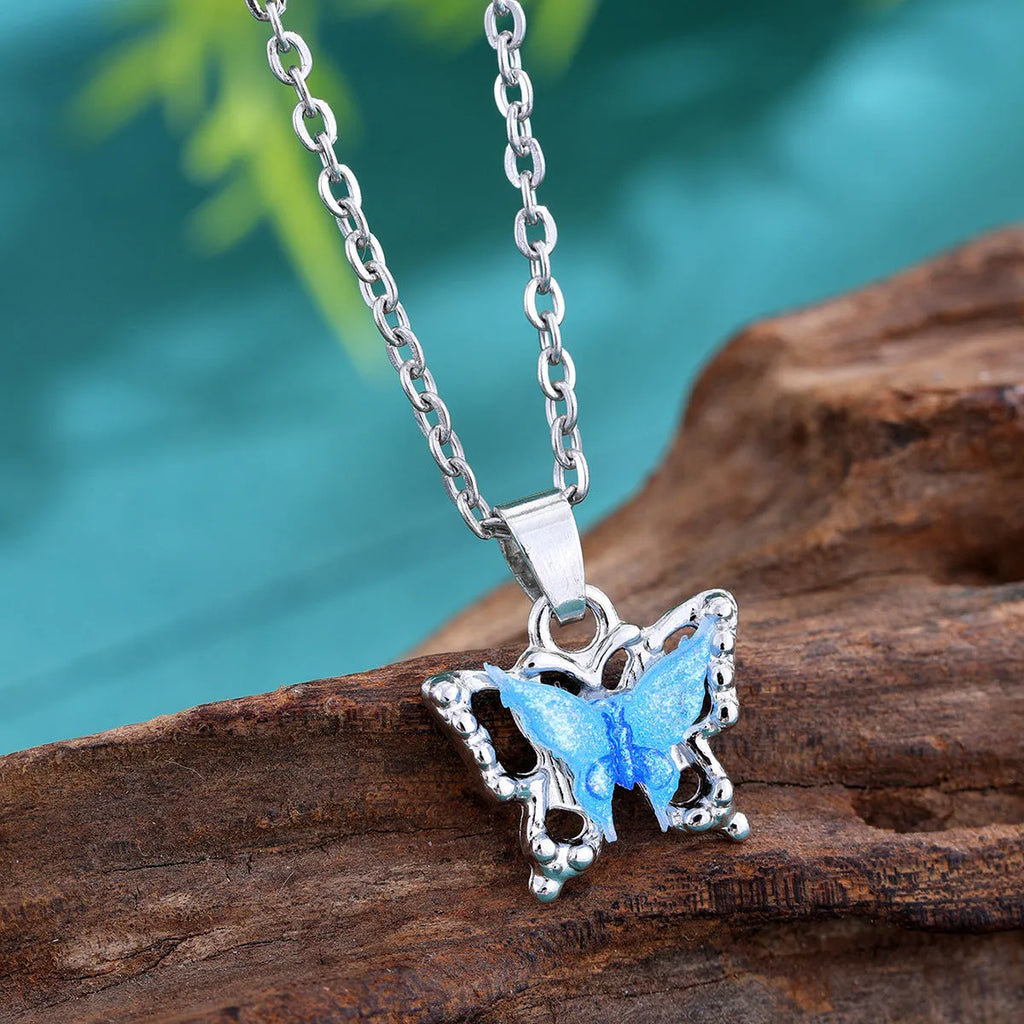 Blue three-dimensional butterfly pendant necklace for women on a light background