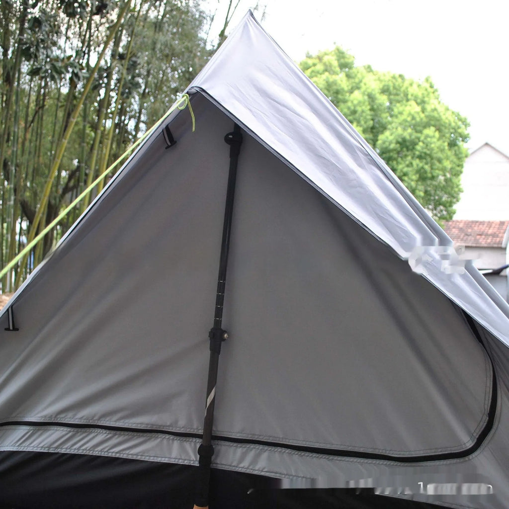 Brown A-line hiking tent pitched using trekking poles with guy ropes secured