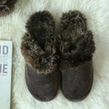 Beige couple wool slippers with suede upper and artificial wool trim on a wooden floor