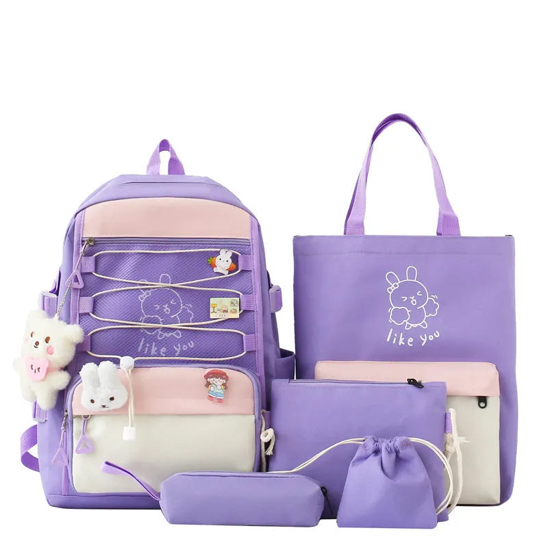 Set of four solid-colour nylon backpacks for students in pink, black, purple, and blue.