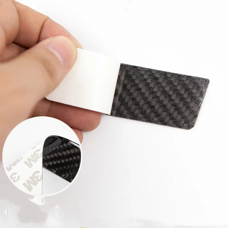 Four black carbon fibre pattern adhesive door handle protectors for a Tesla Model S.