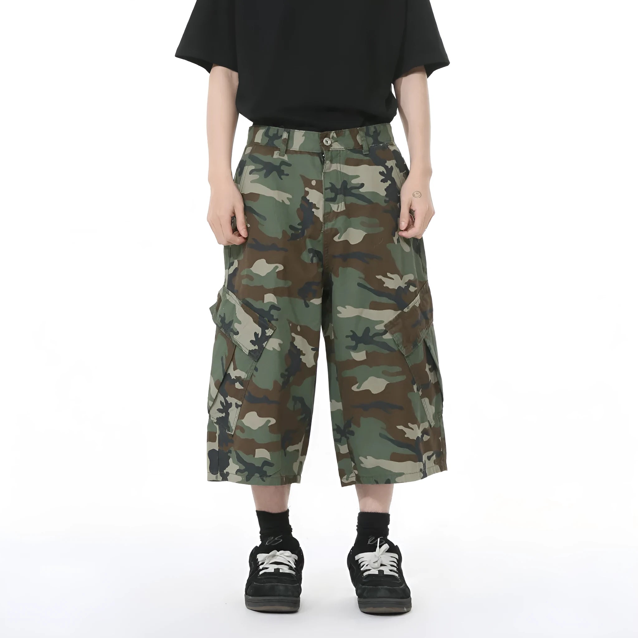 Man wearing loose camouflage print cotton jeans with wide legs and side stitching.