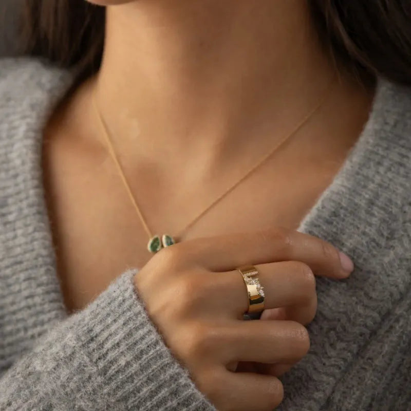 Gold plated women's ring with a shining zircon stone on a model's hand.