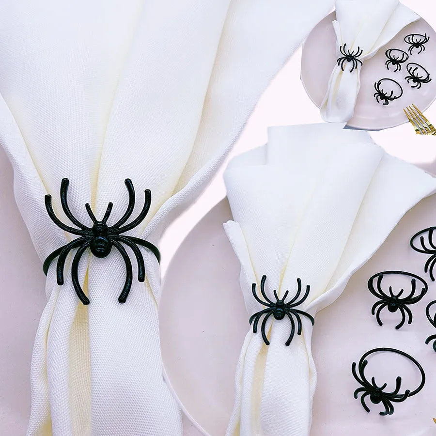 Set of six black alloy spider-shaped napkin rings for Halloween table decoration.