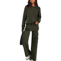 Woman wearing a long sleeve top and full-length trousers from a matching polyester sports set in a neutral colour.