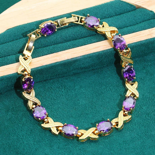 Gold plated jewellery set with coloured cubic zirconia stones, showing necklace, earrings, ring, and bracelet.