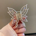 Butterfly-shaped alloy hair clip for women with rhinestone or pearl decoration.