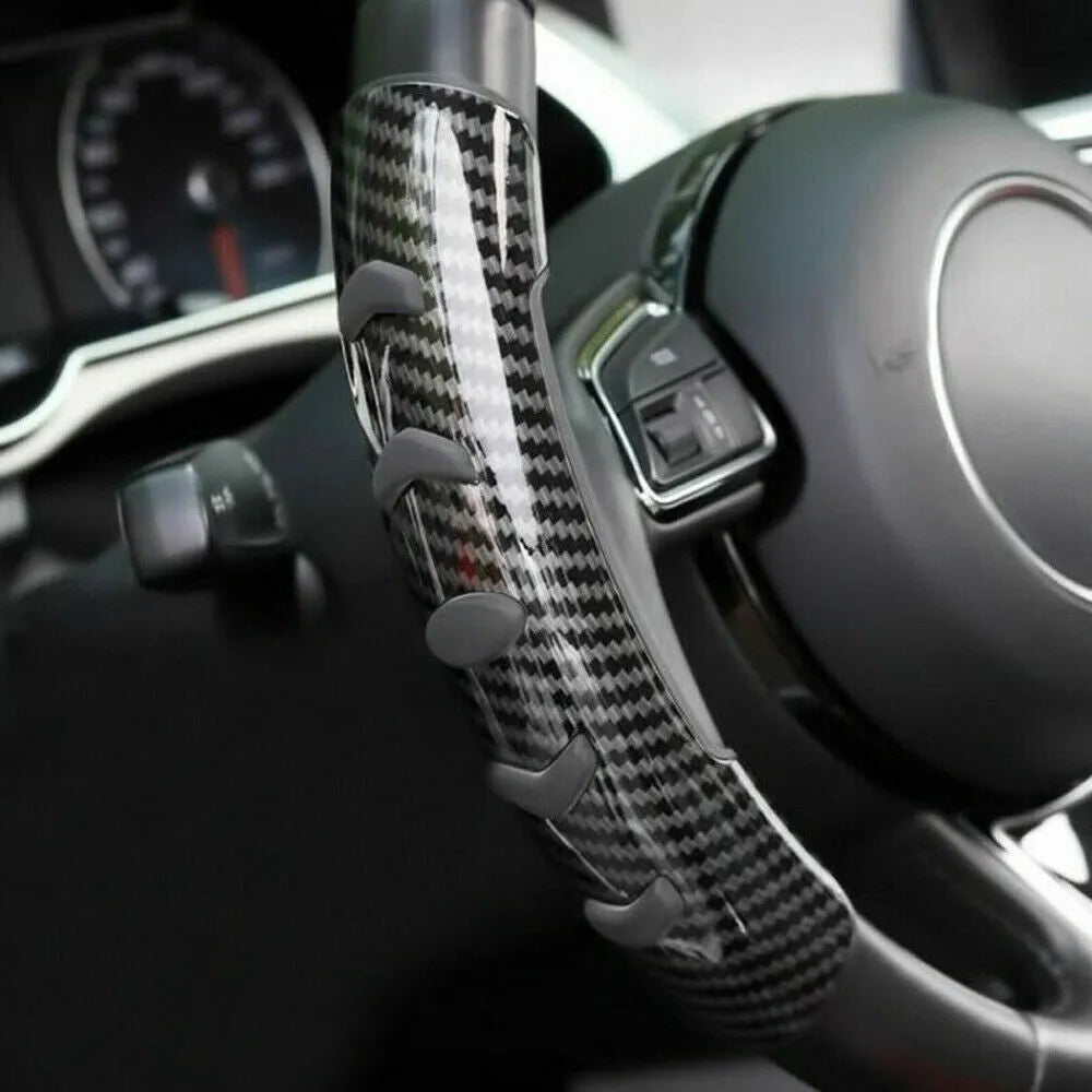 Carbon fibre black anti-slip sleeve fitted on a car steering wheel.