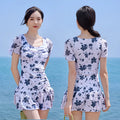 Women's white mesh short sleeve one-piece swimming dress on a mannequin.