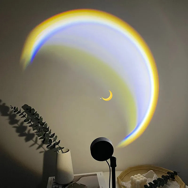 INS USB Moon Lamp LED projector on a table projecting rainbow light onto a wall.