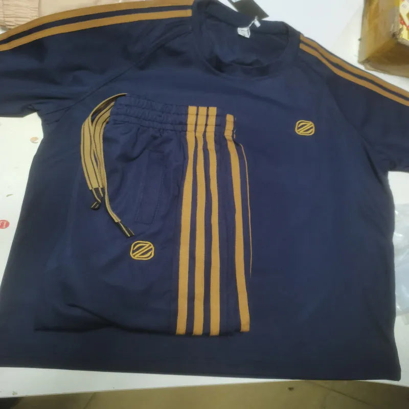 Man wearing a blue ice silk style short sleeve tracksuit set, showing the top and pants.