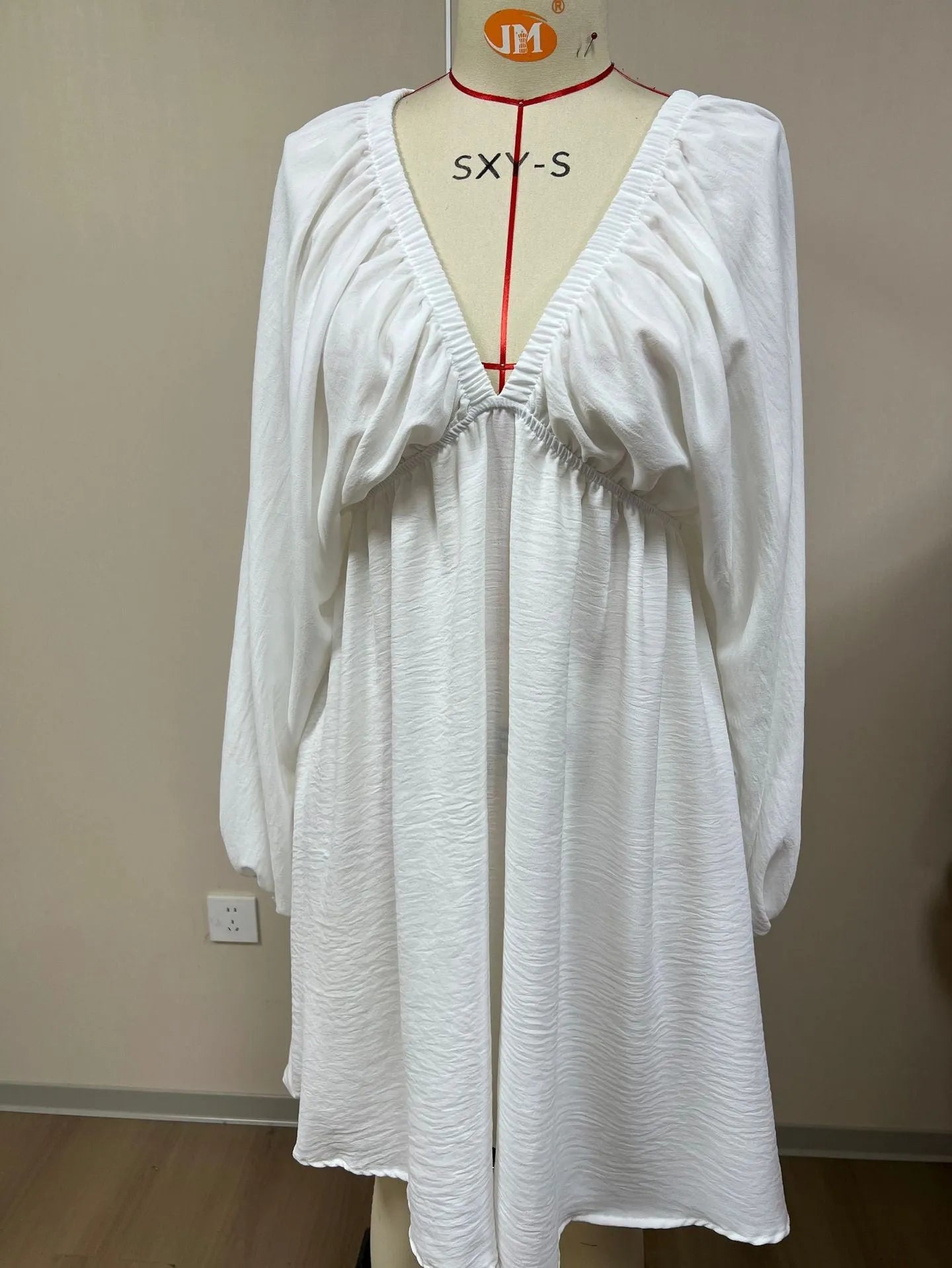 Solid colour V-neck dress with long puff sleeves and a mid-waist swing skirt.