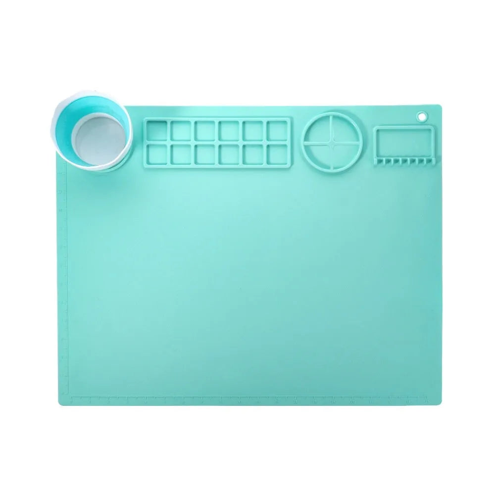 Light blue silicone painting mat measuring 50 by 40 cm on a wooden table