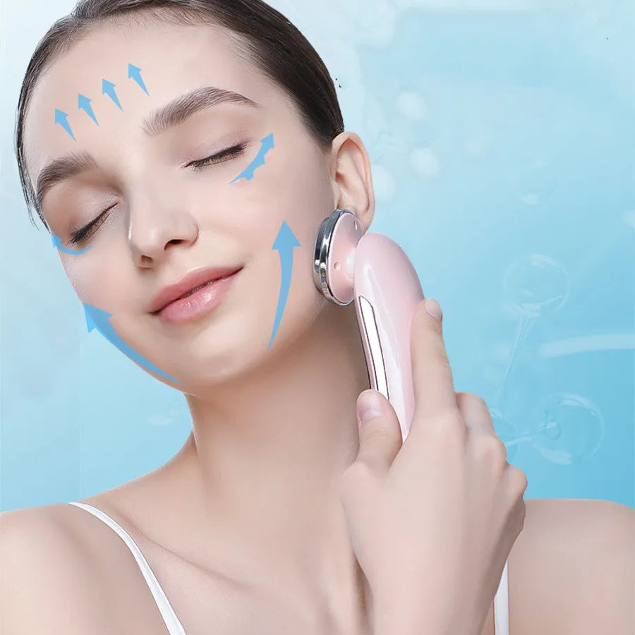 Pink and white rechargeable facial massager with red and blue light therapy functions on a clean surface