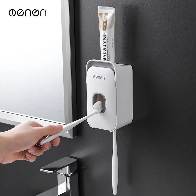 Blue automatic toothpaste dispenser mounted on a bathroom wall with a push-button for one-handed use.