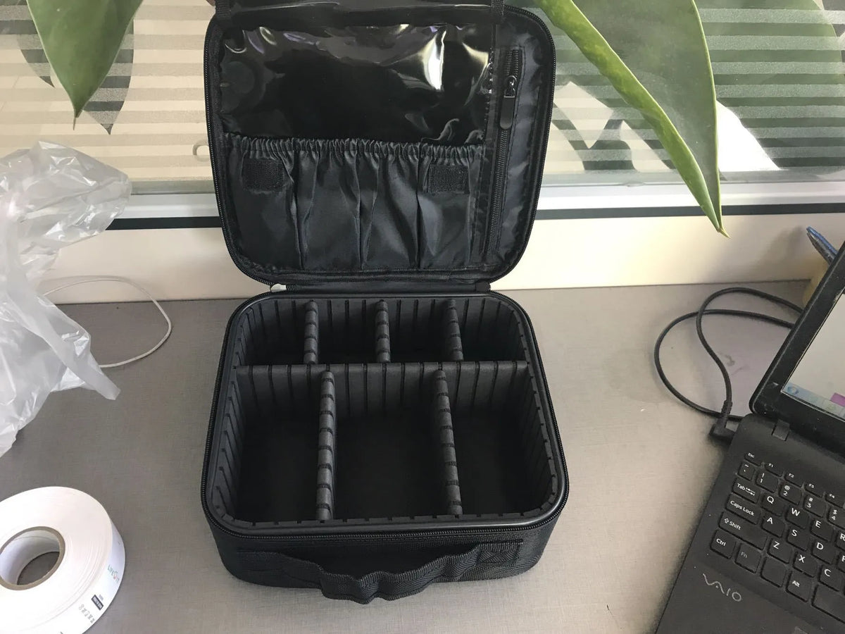 Mini black nylon cosmetic bag with zip closure, 26x22x12cm, shown open with make-up inside