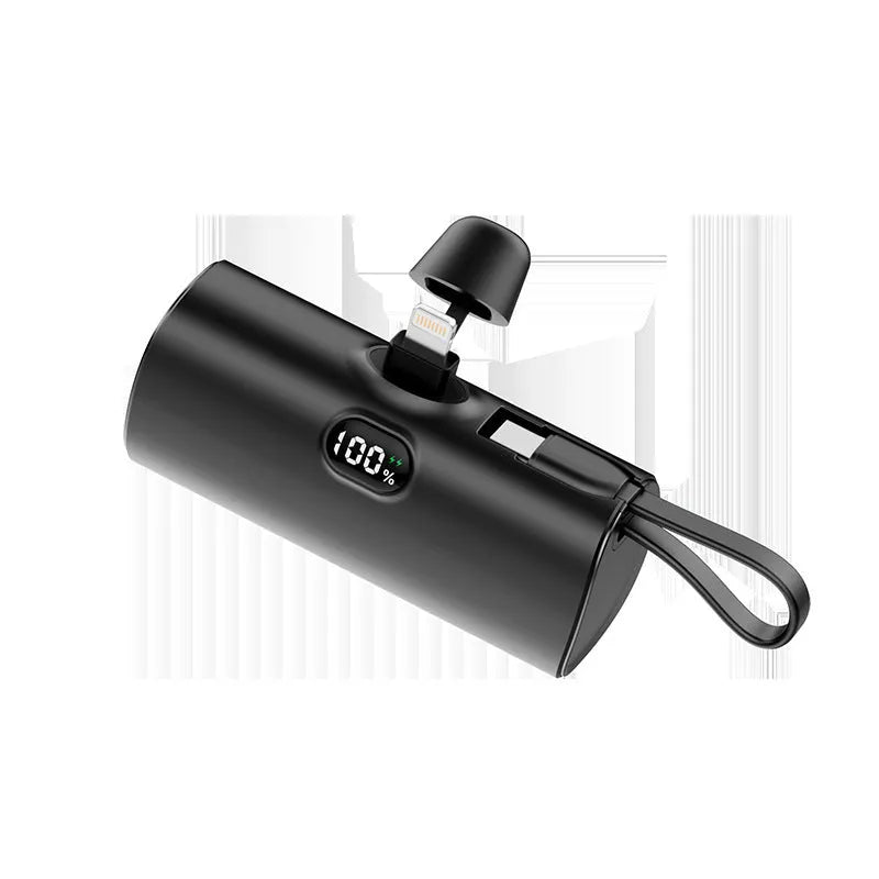 Compact capsule-shaped wireless power bank with a UK plug and digital display, shown in pink.