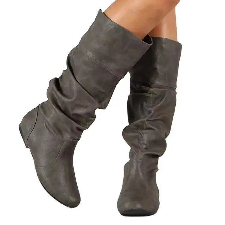 Women's flat black slip-on ankle boots with a round toe and high-top design on a neutral background.