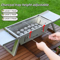 Small foldable metal charcoal grill for outdoor barbecues, shown in open cooking position.