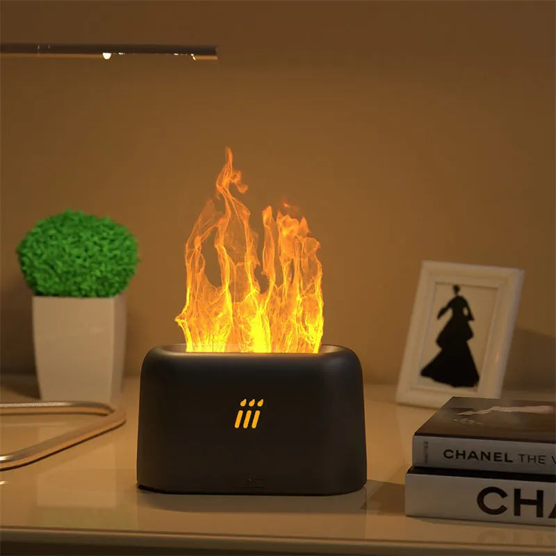 Black round ultrasonic humidifier and aroma diffuser with flame effect LED lights on a table.