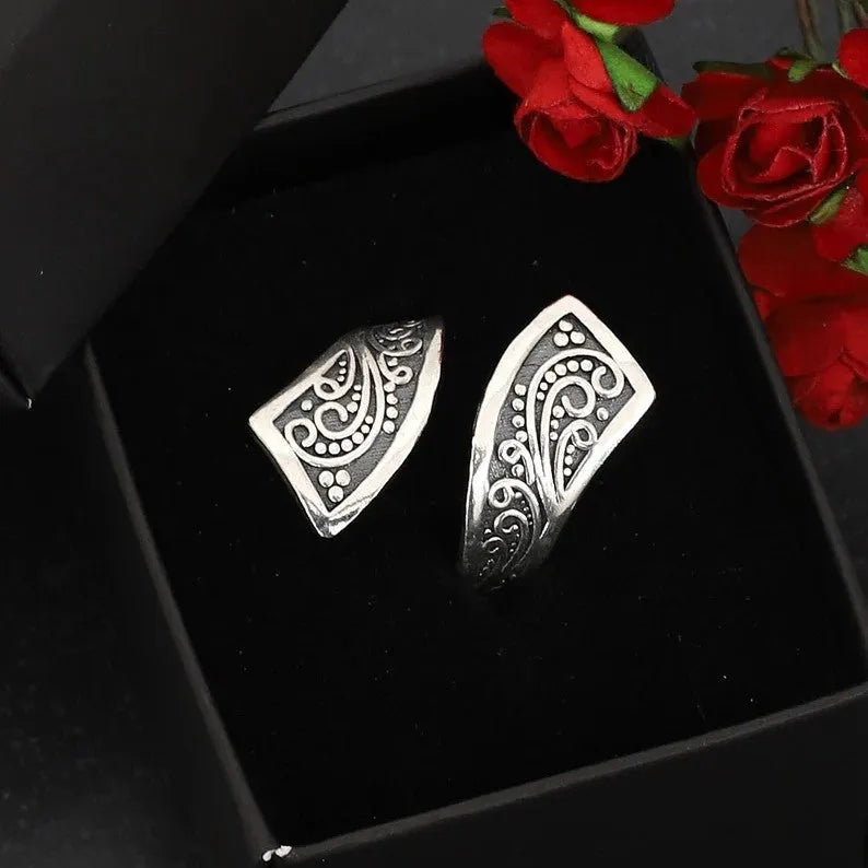 Silver-coloured adjustable minimalist women's ring with a retro design on a plain background.