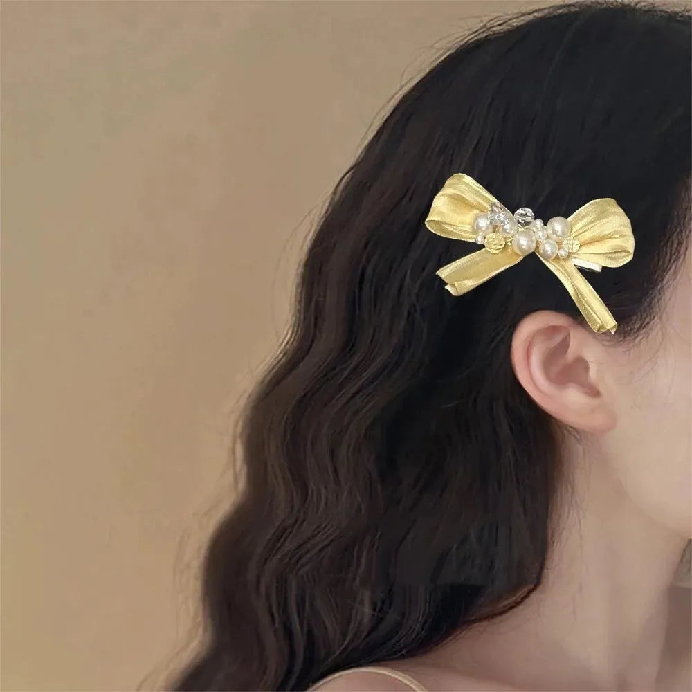 Yellow fabric bow barrette with rhinestone pearls on duckbill hair clip