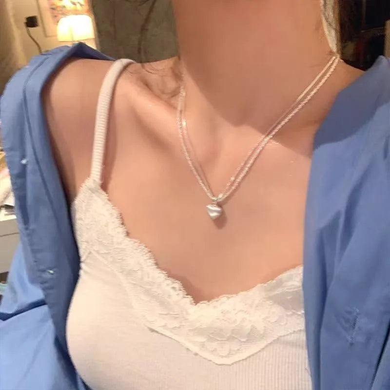 Double-layer brushed heart necklace with adjustable chain on white background