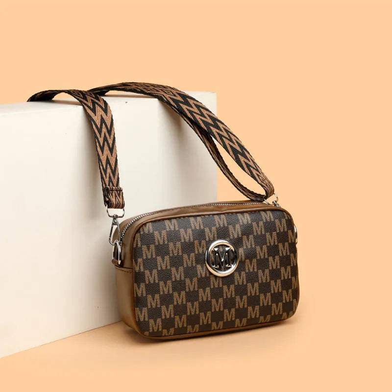 Crossbody bag with wide shoulder strap showing three-dimensional front pocket organisation
