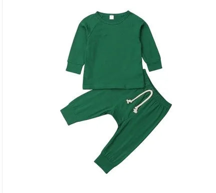 A baby wearing a blue cotton romper tracksuit set with a cartoon pattern, showing the one-piece design.