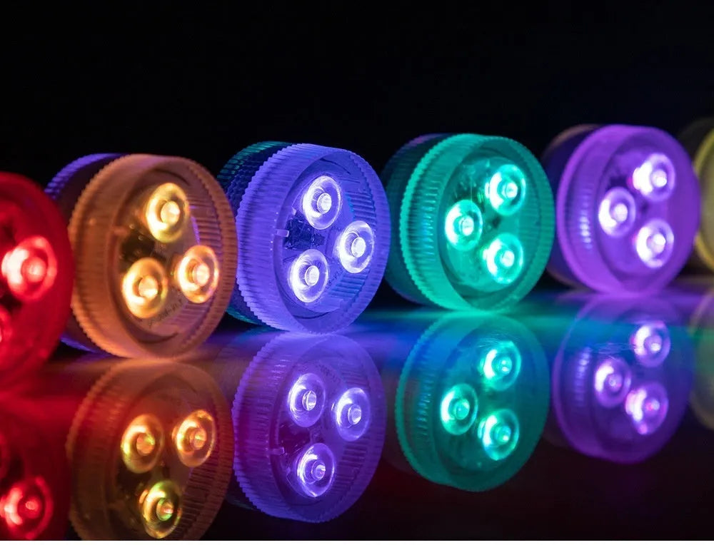Small round submersible LED aquarium light with remote control on a white background