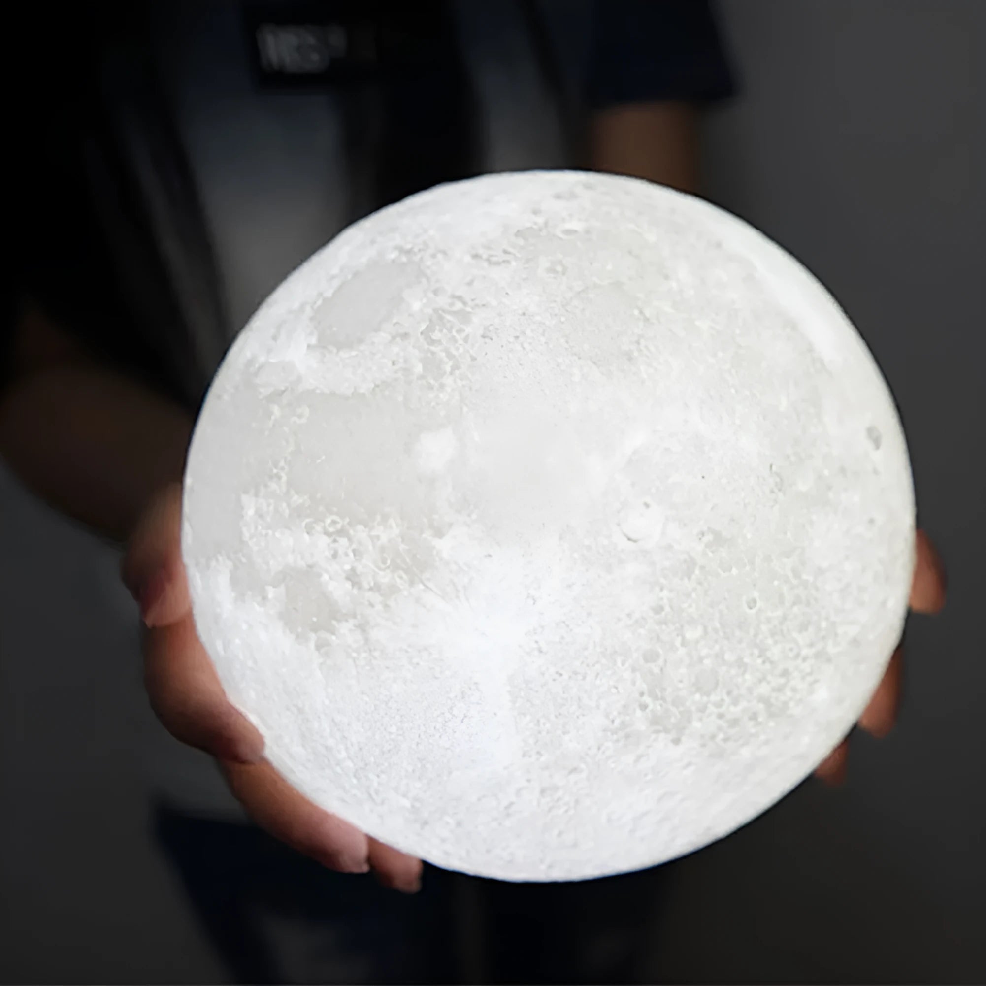 3D printed white moon lamp with textured surface on a wooden stand, showing touch ring at base
