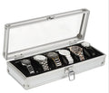 Brushed aluminium watch box holding six watches with a front jewellery storage bin.