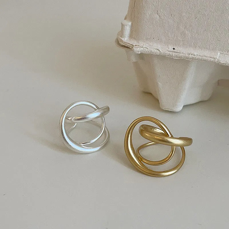 Geometric interlaced matte metal open ring for women in gold or silver colour.