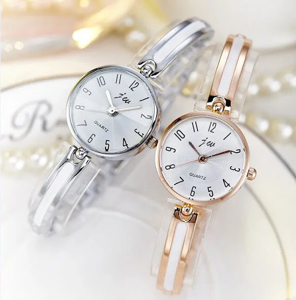 Gold dial quartz watch with steel strap and mineral glass mirror on light background
