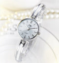 Gold dial quartz watch with steel strap and mineral glass mirror on light background