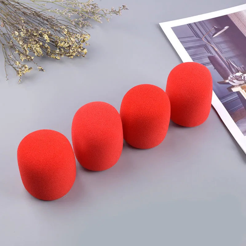 Four multicolored foam microphone windshields for handheld stage microphones on a grey background.