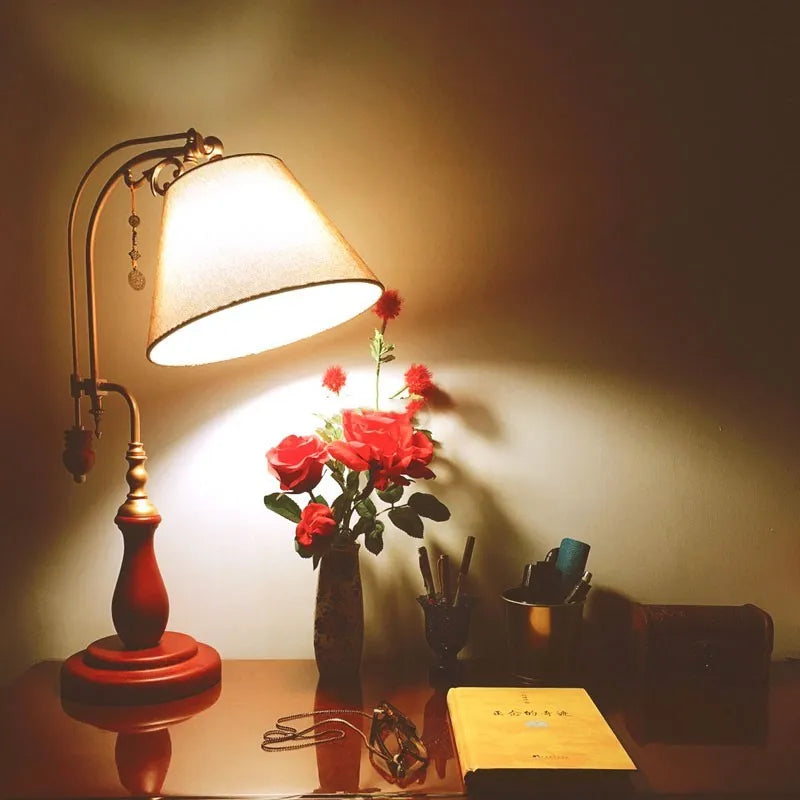 Beige fabric shade wooden bedside table lamp on a wooden surface