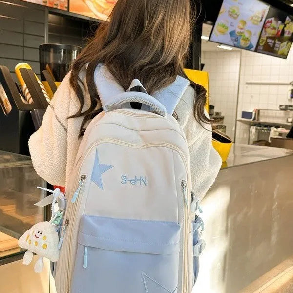 Mori style nylon backpack for women, light blue colour, shown with pendant on a plain background