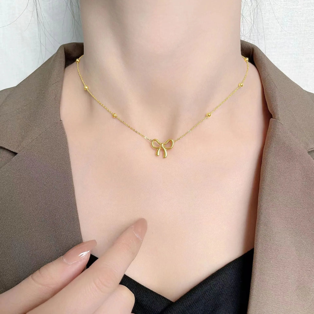 Gold electroplated titanium steel necklace with bow design and cross chain links