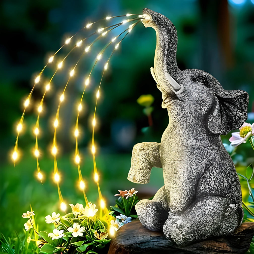 Grey resin elephant garden statue with solar-powered LED lights on its back.