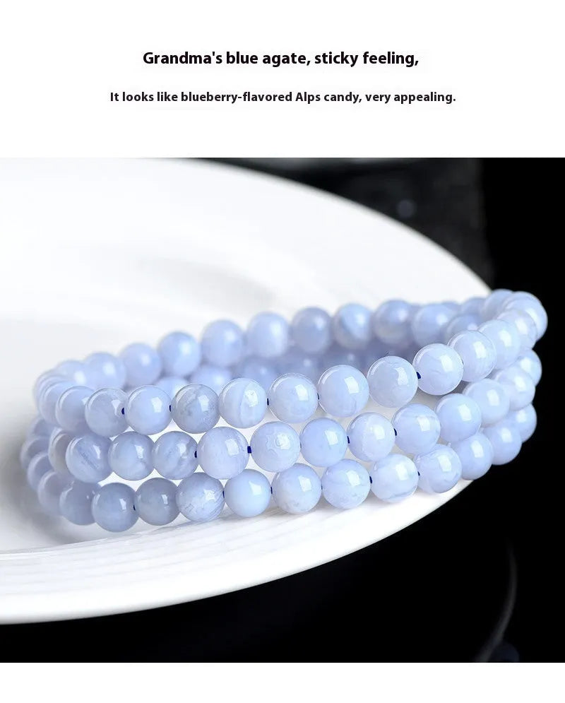 Blue agate bead bracelet with striped patterns and a Ruyi charm on a white background.