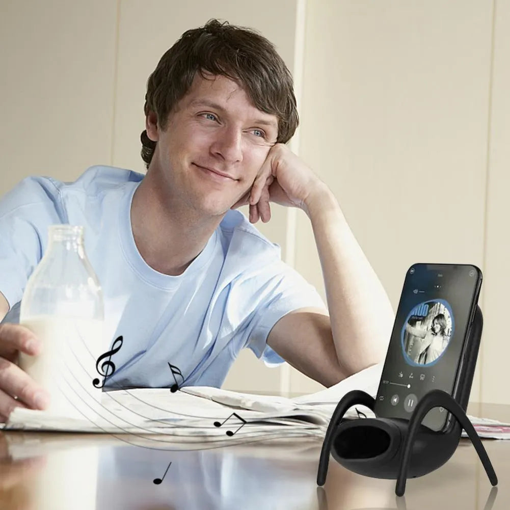 White mini chair-shaped wireless charging stand holding a mobile phone at an angle.